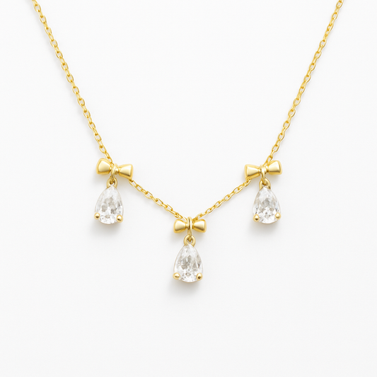 18k gold plated white crystal bow necklace by Juwelenn – gold necklace with teardrop white stones and bow charms
